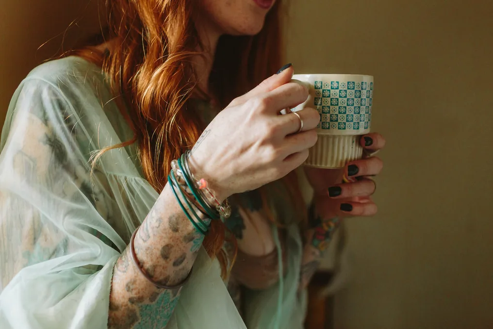 Close-up of a hand holding a patterned mug